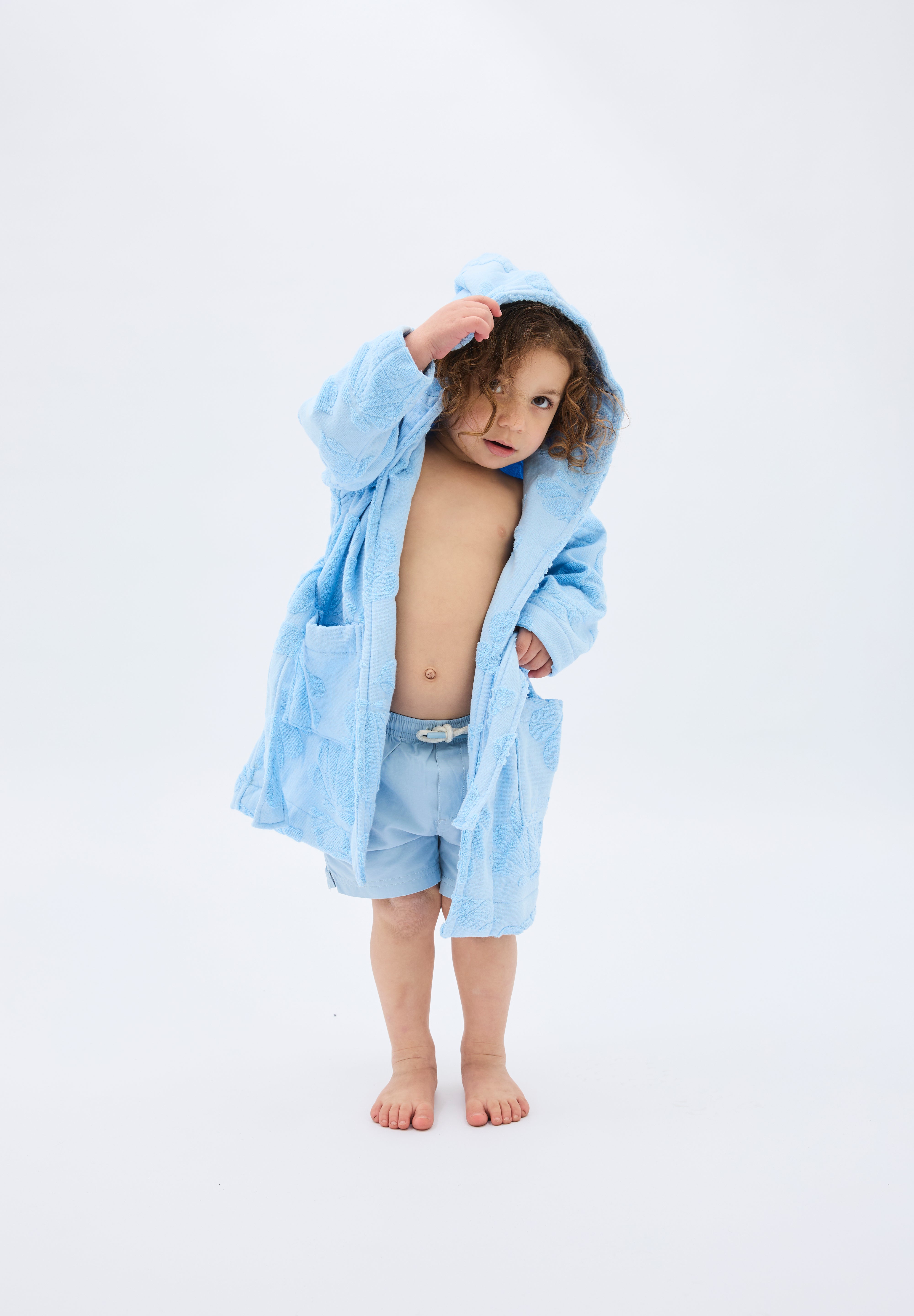 Child wearing a light blue robe on a white background