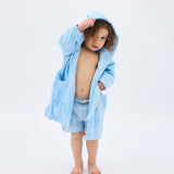 Child wearing a light blue robe on a white background